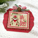  Red wooden ornament display with a mounted cross stitch design reading "Oh Deer," with a reindeer in a red scarf, holly, snowflakes, evergreen sprigs, and a striped bow with a jingle bell.