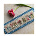 Photo of the finished pattern on a striped fabric board laid next to a pink flower.