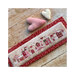 Photo of the finished pattern on a red floral fabric board laid next to a pink and white heart.