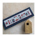 Photo of the finished pattern on a blue fabric board laid next to a birdhouse.
