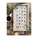 Finished full Advent stamp calendar design in a wood frame surrounded by a coffee mug, candle, pine boughs, and berries on a wood plank background.
