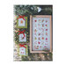 Front cover of the Christmas Stamps cross stitch pattern showing the finished pattern laid on a wooden plank table on top of pine boughs, holy sprigs, and Christmas lights next to the alternative stamp designs.