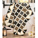 The completed Simply Cool Quilt, colored in cozy neutrals from the Black Sheep Cottons collections by Marcus Fabrics, artfully draped over a white barn stall door, staged with coordinating décor.