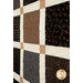 An angled close up on the patchwork of the quilt, demonstrating details on the prints, colors, and top quilting effects.