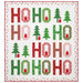 The completed Jollity quilt kit, colored in bright red, green, and white fabrics from the Snow Time collection by Moda Fabrics, isolated on a white background. 