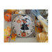 Photo of the finished Halloween - Pumpkin Witch cross stitch pattern finished in a circle hoop on a natural colored linen fabric board next to pumpkins and autumn leaves.