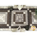 A closer look at the runner staged with coordinating table settings, demonstrating fabric prints and patchwork details.