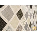 An angled close up on the patchwork, demonstrating fabric prints, colors, and top quilting effects.