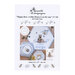 Front cover of the cross stitch pattern with the finished designs scattered across a wood table next to a bowl of applesauce.