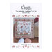 Front cover of the cross stitch pattern with the finished pattern stitched onto a neutral finishing board on a wood table behind two eggs.