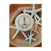 Lighthouse cross stitch pattern laid on a pile of driftwood and seastars.