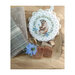Groundhog cross stitch pattern laid in a bowl of wood chunks and a blue flower.