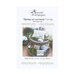 Front cover of the cross stitch pattern with the finished patterns stitched onto pillows in a wooden stand holding spring motifs like flowers and eggs.