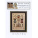 Front cover of the little house neighborhood cross stitch pattern finished in a wooden frame.
