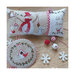 Photo of the finished patterns stitched onto a pillow on top of a wooden table.