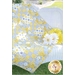 A quilt with a yellow and gray patterned design is draped over a white wicker chair. There are white daisies and a decorative yellow pillow next to the quilt, set in a green outdoor space. The bottom corner features a logo for Shabby Fabrics.