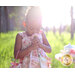 An image of a little girl sniffing a flower in the Tea Party Dress.