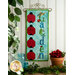 A colorful wall hanging with the word Garden in blue and green letters, surrounded by various ladybug designs. The background is light blue, and the hanging is decorated with a small hat and a flower. Below, there are potted flowers and green foliage.