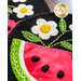 Close-up of colorful wool appliqué featuring a watermelon slice and white flowers with yellow centers, set against a dark background. Green embroidery stitches enhance the design.