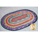 The full finished Jelly Roll Rug displayed on a white wooden floor.