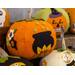 A collection of decorative felt pumpkins in various colors and designs, including an orange pumpkin adorned with a black cauldron and flowers, set against a blurred background of additional themed pumpkins.