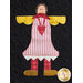 A fabric applique design featuring a whimsical figure with a round face, yellow sleeves, and a striped dress. The figure has a heart emblem on its chest and is set against a black quilted background.