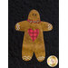 A fabric gingerbread man decoration with a red and black checkered heart design on its chest, adorned with a red beaded necklace. The background is dark with a quilted pattern.