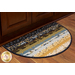 A decorative half-oval area rug with a colorful patterned design, featuring stripes of blue, gold, and cream, placed in front of a wooden cabinet.