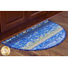 A half-oval area rug with a blue and yellow patchwork design, placed under kitchen cabinetry on a wooden floor.