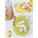 A decorative green felt Easter egg adorned with a white bunny and colorful flowers, placed next to a white basket filled with pastel-colored eggs.