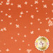 A swatch of fabric showing light peach colored florals scattered on a burnt orange background