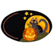 The completed October wooly mug mat with a cat and Jack-o'-lantern resting on a hill in front of a moon and stars with an embroidered edge, isolated on a white background.