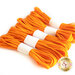 Five bundles of bright orange elastic cords, each secured with a white band, are neatly arranged in a row.