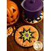 Two Halloween cloth hot pads on a wood table with a pot resting on one