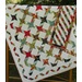 A colorful, patterned quilt with a mix of stars and geometric shapes, draped over a wooden quilt ladder.