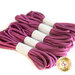 Five bundles of mauve elastic wraps are neatly arranged with white wraps around them.