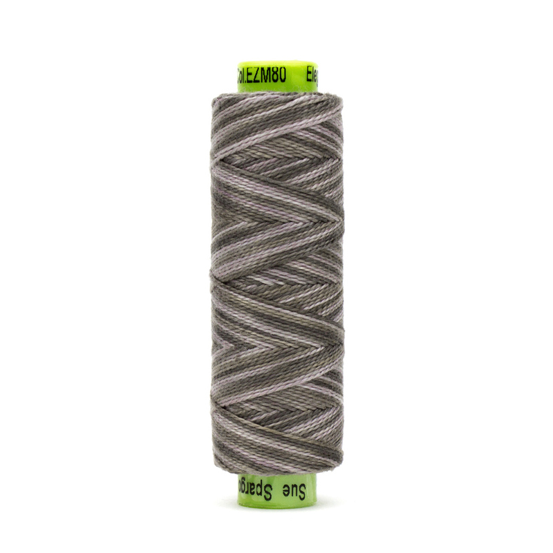 A spool of WonderFil Eleganza EZM80 Sardine Box thread on a white background