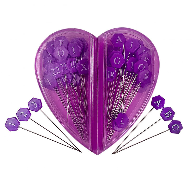 A plastic purple heart shaped pack full of purple hexagon pins and 6 pins showing the numbers 1-3 and the letters A-C