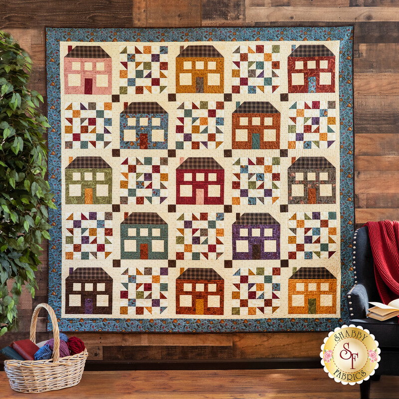 A colorful quilt with house blocks and checkered lattice designs