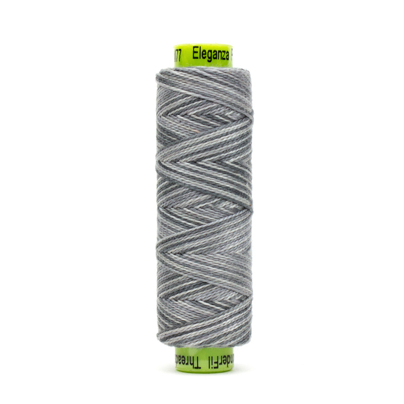 A spool of WonderFil Eleganza EZM77 Captain Gray thread on a white background