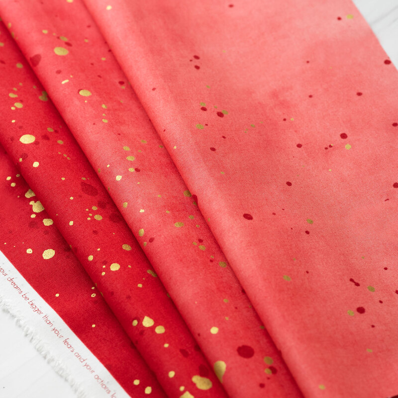 A red/pink ombre fabric with metallic accents.