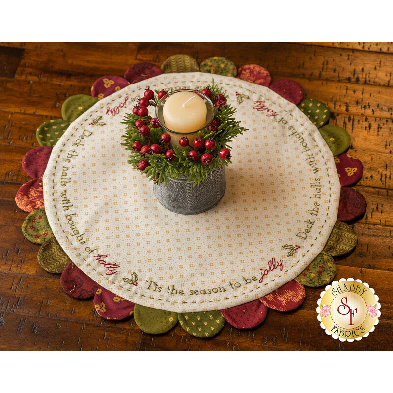 Cream Scalloped Table Topper with muted red and green scallops featuring Christmas themed embroidery.