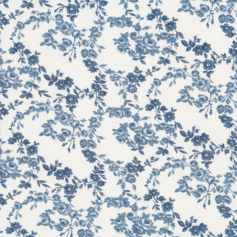 Fabric with blue floral vines all over a cream background