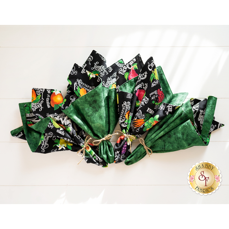 Cloth napkins with marbled green on one side and black with produce themed prints on the other.