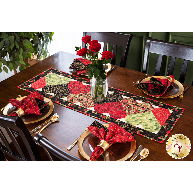 Table runner with interlocking heart design featuring rose themed prints in red, black, and green.