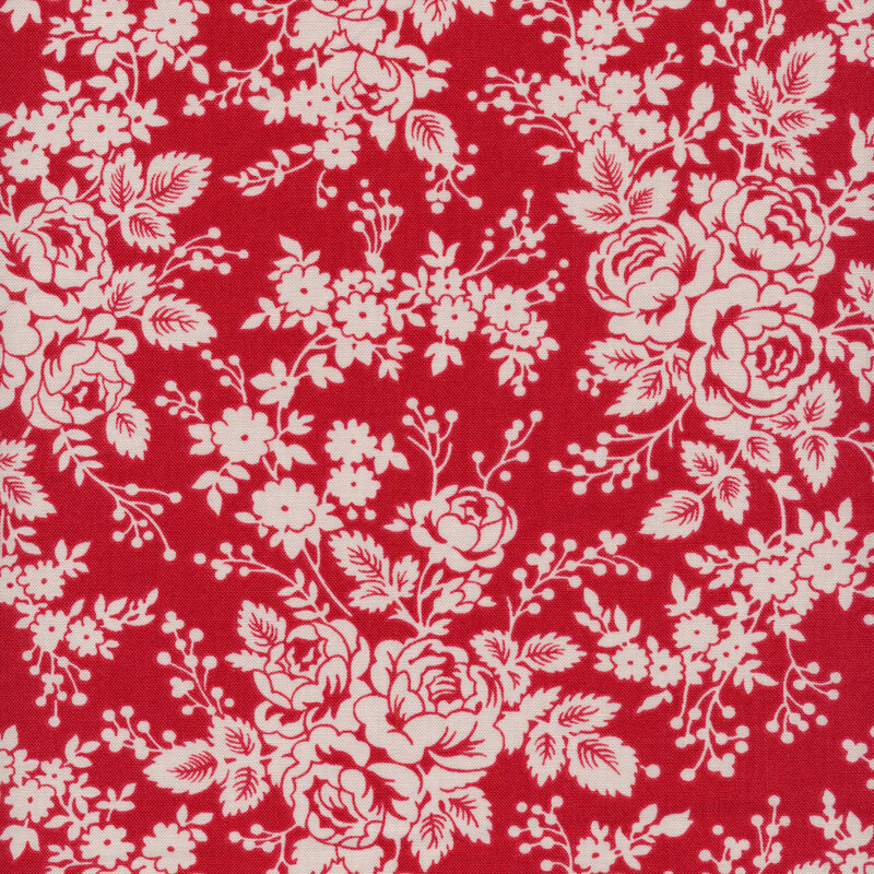 Fabric of cream clusters flowers, sprigs, and leaves on a red background