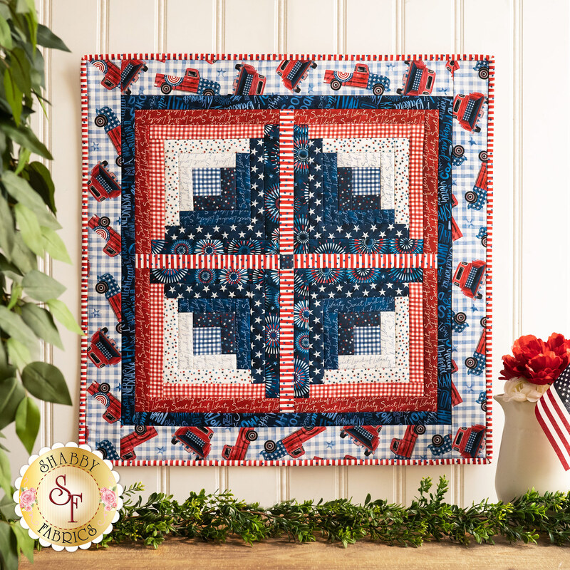 Wall hanging with four squares made up of strips of red, white, and blue patriotic fabric prints.