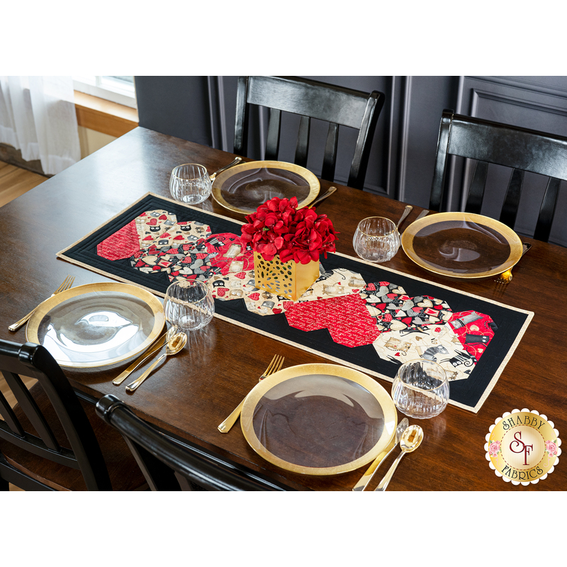 Table runner with interlocking hearts design made of illustrated cat printed fabrics and black border.