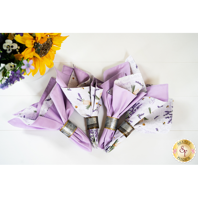 Two sided cloth napkins one side with purple fabric the other with white fabric featuring lavender prints.