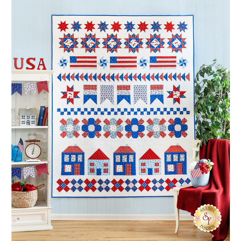 Quilt with rows of designs including stars, flags, houses, flowers, and various geometric shapes all made of red, white, and blue fabric,